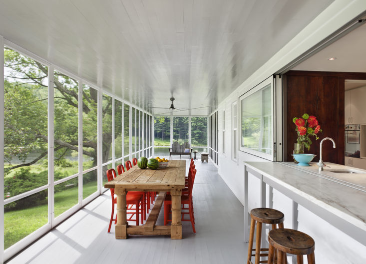 The screened porch can become a glazed porch and becomes usable for three seasons; sometimes even in the winter when the weather is mild, which gives the family more space during the winter and yet retaining its airiness in the summer. Photograph by Michael Moran, from The Architect Is In: Porch Appreciation in Connecticut.